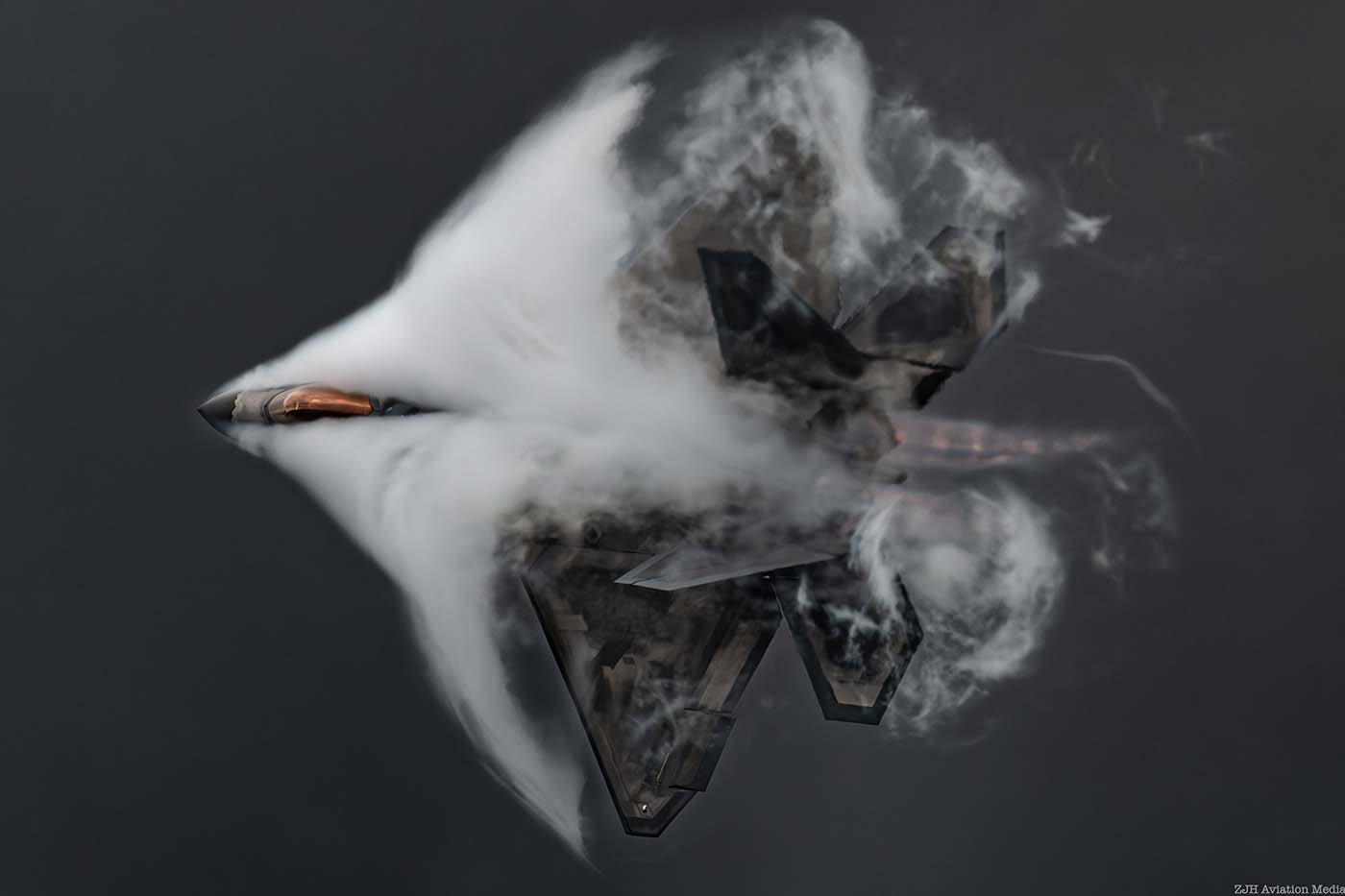 F-22 Raptor top side with vapor in a cloudy grey sky